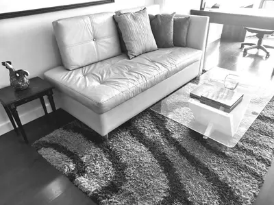 a leather couch in a living room with a rug at Espacio Luxury Apartments Malecón 2 in Lima