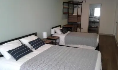 a bedroom with two beds and a staircase in it at NEREO rooms in Lima