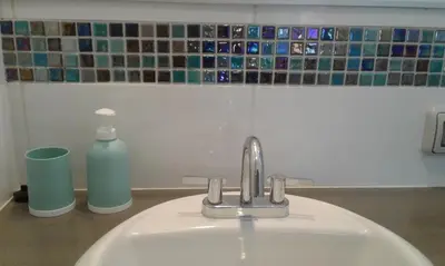 a sink with a faucet and a bottle of soap at NEREO rooms in Lima