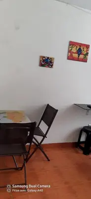 a table and chairs in a room with a white wall at Acojedor in Lima