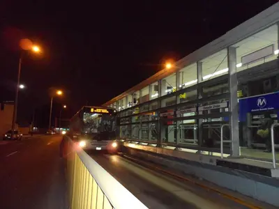 a bus driving down a street next to a building at night at Hostal Jovita in Lima