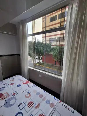 a bedroom with a bed and a large window at Hostal Jovita in Lima