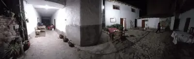 an alley with a building and a person walking in the distance at CHINA SAQRA in Cusco