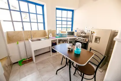 a small kitchen with a table and a sink at PARDOS HOUSE INN in Cusco