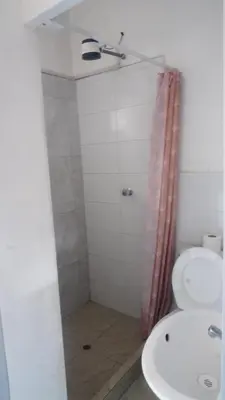 a bathroom with a shower and a toilet and a sink at PARDOS HOUSE INN in Cusco