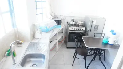 a small kitchen with a sink and a table at PARDOS HOUSE INN in Cusco