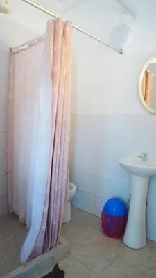 a bathroom with a shower curtain and a sink at PARDOS HOUSE INN in Cusco