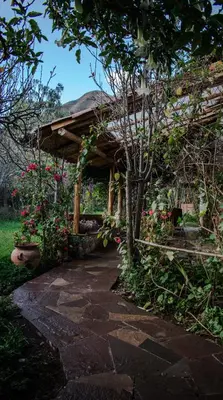 a stone walkway leading to a house with a roof at Eco Lodge Los Perales-Urubamba in Urubamba