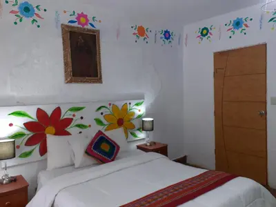 a bedroom with a bed with flowers on the wall at Reinbo Garden in Cusco