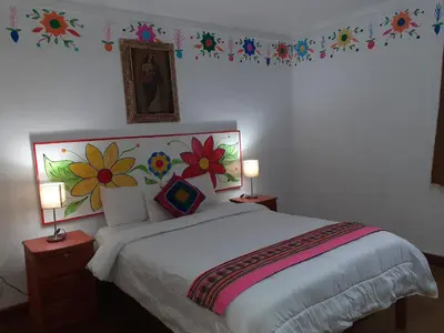 a bedroom with a bed with flowers on the wall at Reinbo Garden in Cusco