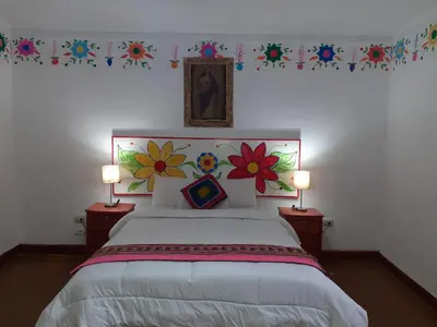a bedroom with a bed with flowers on the wall at Reinbo Garden in Cusco