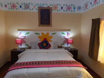 a bedroom with a bed with flowers on the wall at Reinbo Garden in Cusco