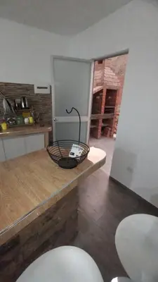a kitchen with a counter with two chairs and a table at Tranquilidad y Sol in Cieneguilla