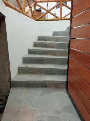 a set of stairs in a room with a wooden door at Tranquilidad y Sol in Cieneguilla