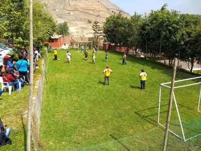 a group of people playing soccer in a field at Amachito's Casa Recreacional in Lima
