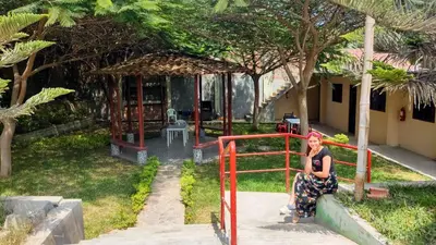 a woman sitting on a fence in a garden at Amachito's Casa Recreacional in Lima