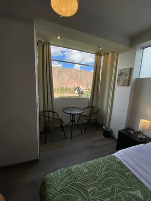 a hotel room with a bed and a table and a window at Casa Yanahuara Valle Sagrado - Urubamba in Urubamba