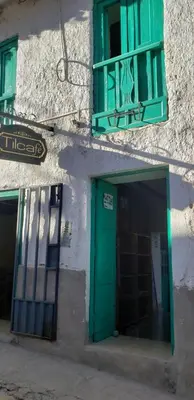 a building with a green door and a window at Tilcafé B&B Mollepata in Mollepata