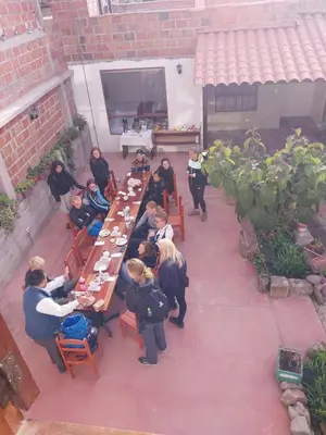 a group of people sitting at a table in a courtyard at Tilcafé B&B Mollepata in Mollepata