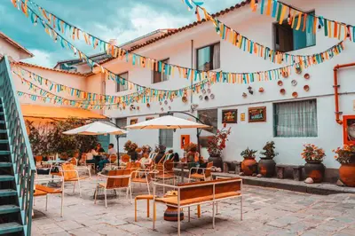 a patio of a restaurant with tables and chairs and flags at Viajero Cusco Hostel in Cusco