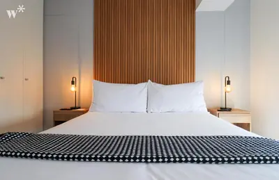 a bedroom with a large bed with white sheets and pillows at Alta by Wynwood House in Lima