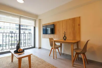 a living room with a desk and a table with chairs at Alta by Wynwood House in Lima