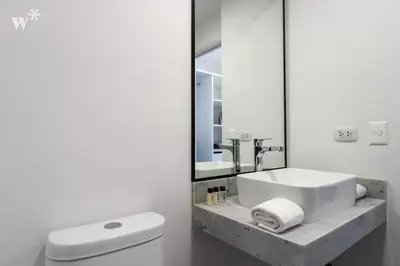 a bathroom with a sink and a toilet and a mirror at Alta by Wynwood House in Lima
