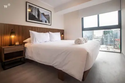 a bedroom with a large bed with a stuffed animal on it at Alta by Wynwood House in Lima