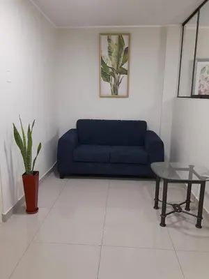 a living room with a blue couch and a table at Casa Las Flores Ica in Ica