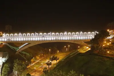 a train is crossing a bridge at night at Terrazas Apartments Miraflores in Lima
