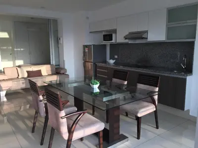 a kitchen and dining room with a glass table and chairs at Terrazas Apartments Miraflores in Lima