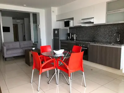 a kitchen with a table and four red chairs at Terrazas Apartments Miraflores in Lima