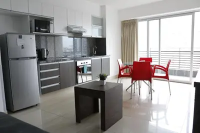 a kitchen and dining room with red chairs and a refrigerator at Terrazas Apartments Miraflores in Lima