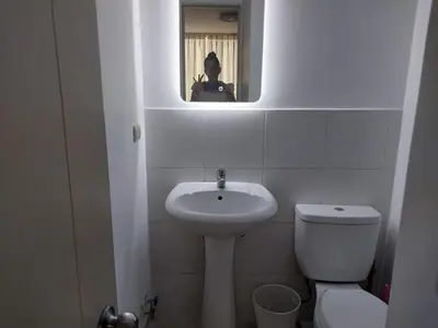 a bathroom with a sink and a toilet and a mirror at departamento de 1 dormitorio in Lima