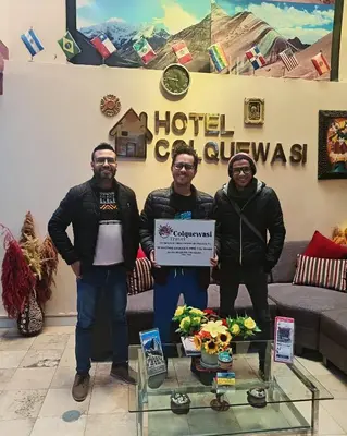 a group of three men holding a cheque at Hotel Colquewasi in Cusco