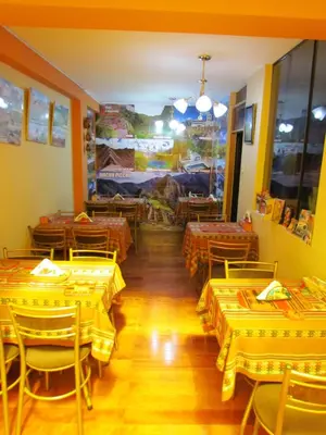 a dining room with yellow tables and chairs with yellow tables at Hotel Colquewasi in Cusco