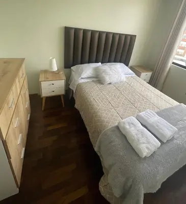 a bedroom with a bed with two towels on it at Departamento completo Surquillo/Miraflores in Lima
