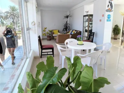 a woman taking a picture of a living room with a table and chairs at Icthus Paracas in Paracas