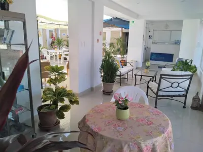 a room with a table and chairs and potted plants at Icthus Paracas in Paracas