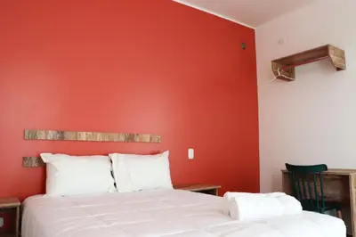 a bedroom with an orange wall and a bed at La Estancia Hotel Ica in Ica