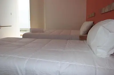 a bedroom with two beds and a window at La Estancia Hotel Ica in Ica