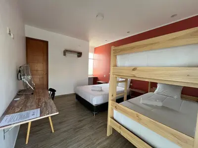 a room with two bunk beds and a table at La Estancia Hotel Ica in Ica