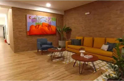 a living room with a yellow couch and two tables at Apartamento acogedor en Barranco - cerca a Miraflores in Lima