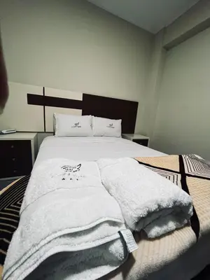 a bedroom with a bed with white towels on it at Hotel La Suite de Angelique Huacho in Huacho