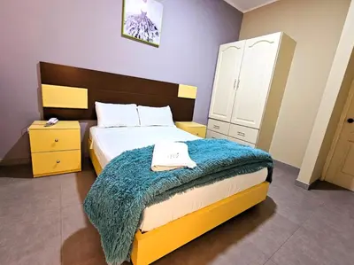 a bedroom with a bed with a blue blanket on it at Hotel La Suite de Angelique Huacho in Huacho