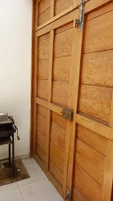 a wooden door in a room next to a piano at Departamentos Cerro Azul P1 in Cerro Azul