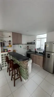 a kitchen with a refrigerator and a table and chairs at Departamentos Cerro Azul P1 in Cerro Azul