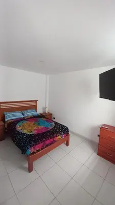 a bedroom with a bed and a flat screen tv at Departamentos Cerro Azul P1 in Cerro Azul
