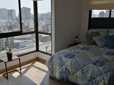 a bedroom with a bed and a large window at MODERNO LOFT BARRANCO, VISTA PANORAMICA in Lima