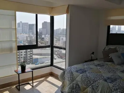 a bedroom with a bed and a view of a city at MODERNO LOFT BARRANCO, VISTA PANORAMICA in Lima